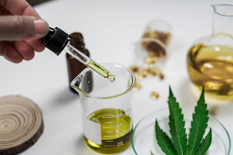 CBD wird aus einem Glas entnommen