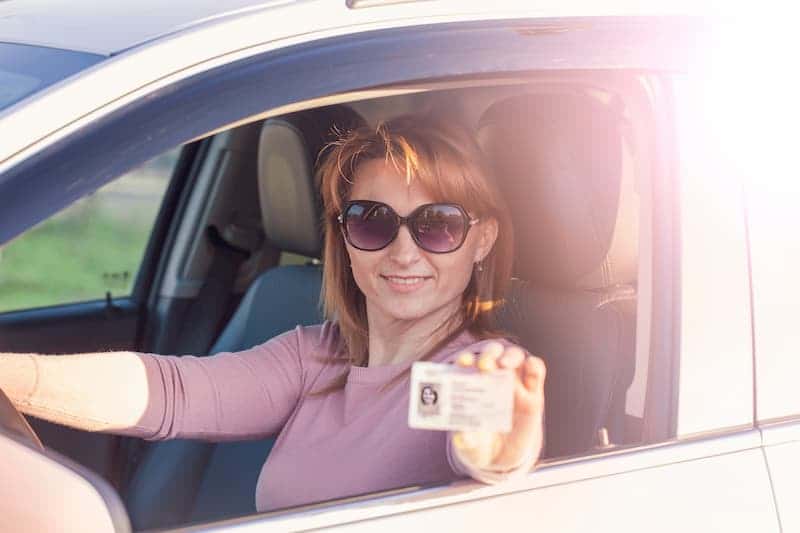 frau-sitzt-im-auto-und-haelt-fuehrerschein