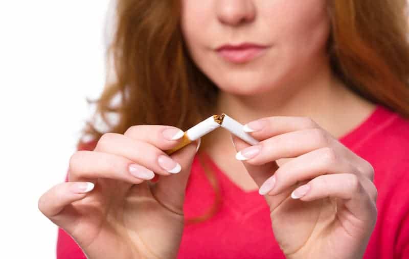 junge-frau-bricht-zigarette-durch-um-mit-dem-rauchen-aufzuhoeren