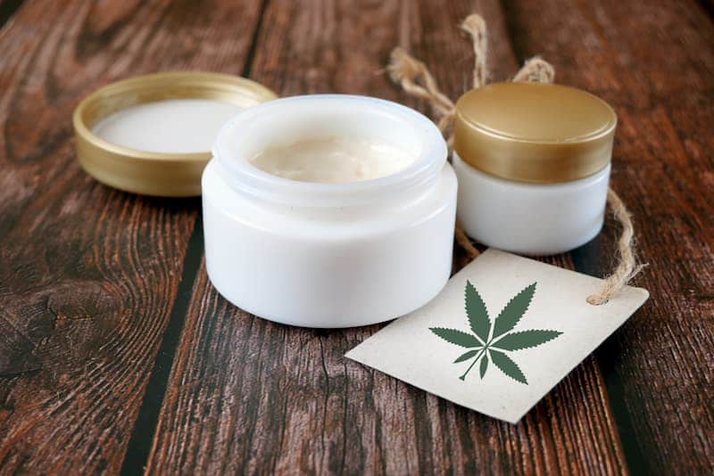 Ein Topf mit CBD-Kosmetik geöffnet auf einem Tisch